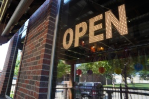 Illuminated OPEN sign in the window of a local storefront