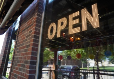 Illuminated OPEN sign in the window of a local business