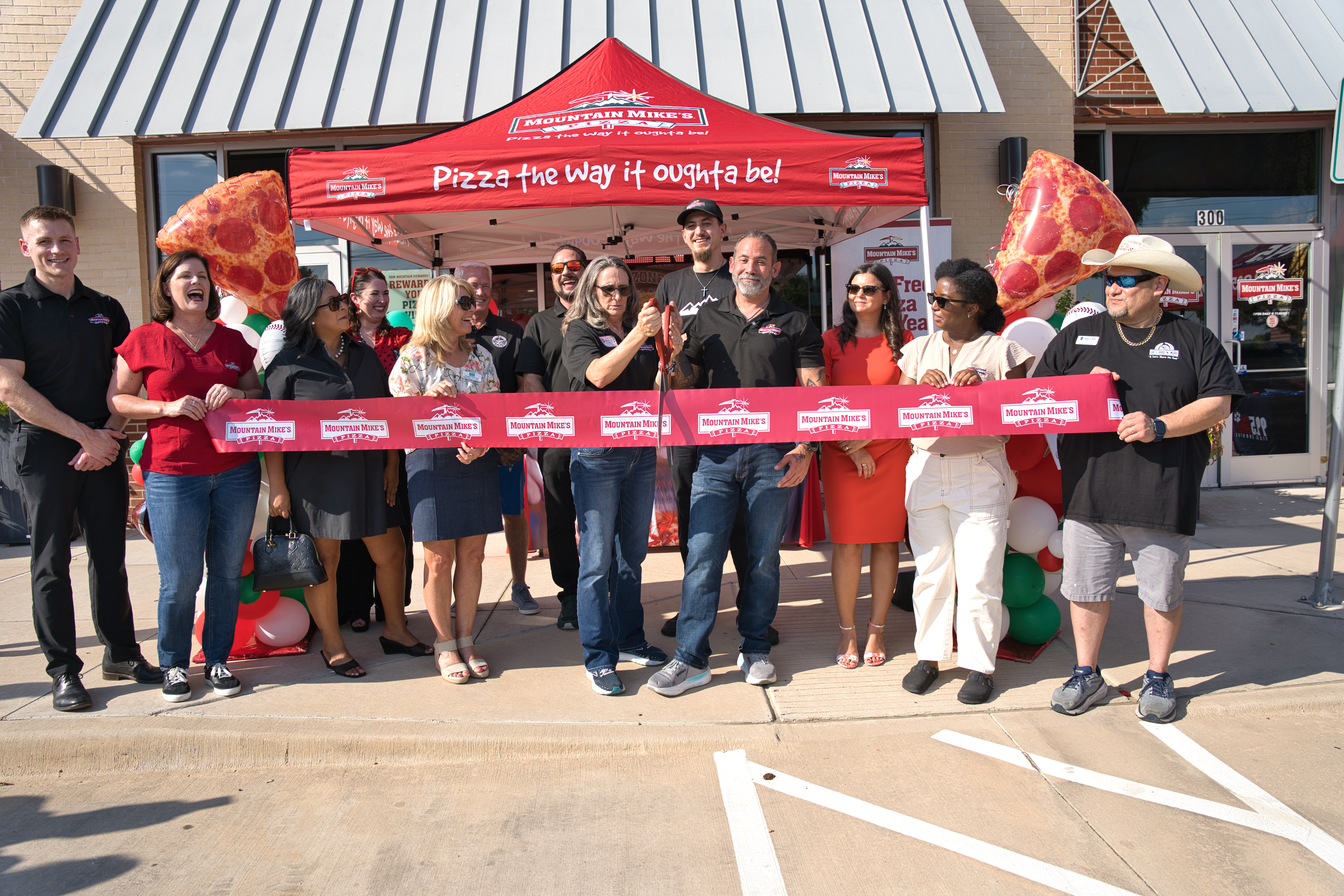 Mountain Mike’s Pizza Keller owners Mason and Lynn Tarin cutting the ribbon with the Greater Keller Chamber and community partners