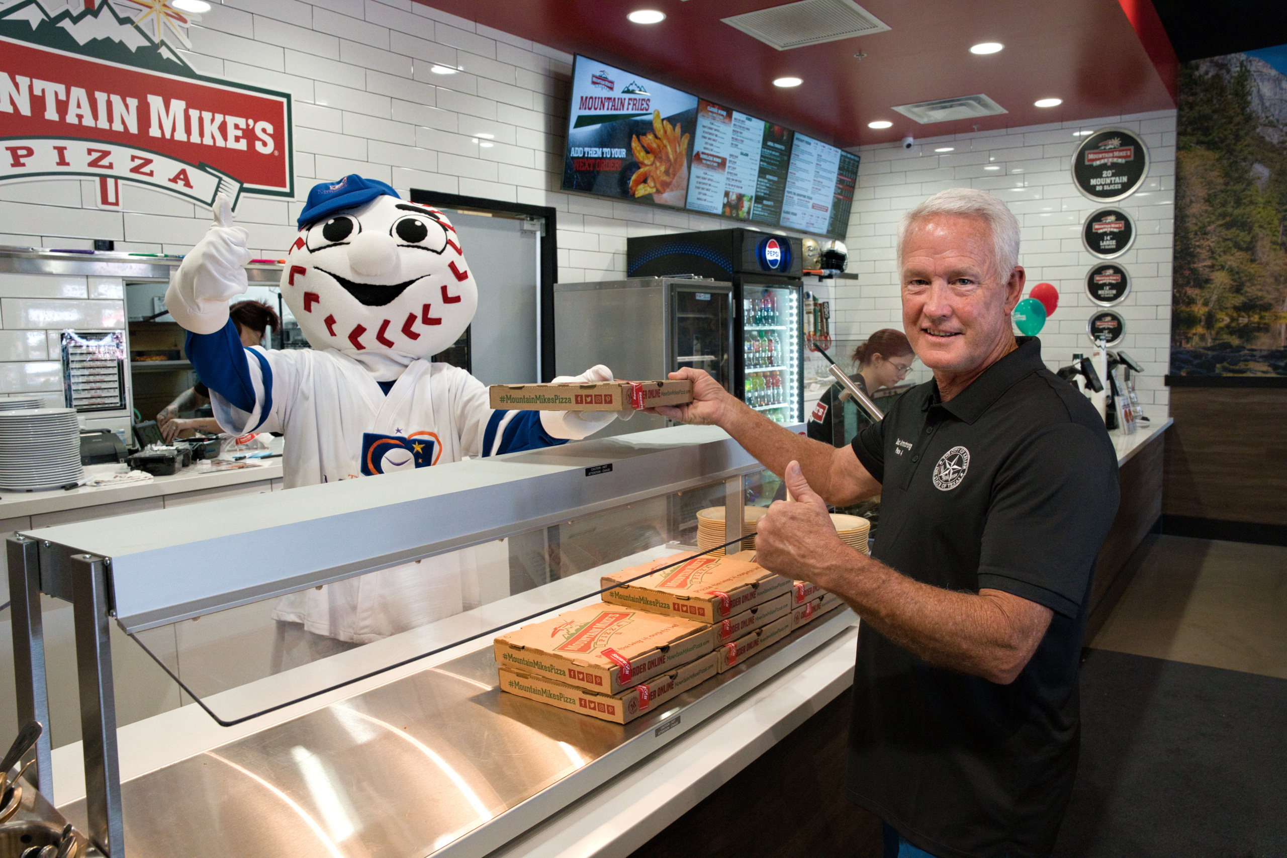 Keller City Councilman Jarrett Doc Armstrong receiving pizza from Homer at the Mountain Mike’s Pizza Keller grand reopening