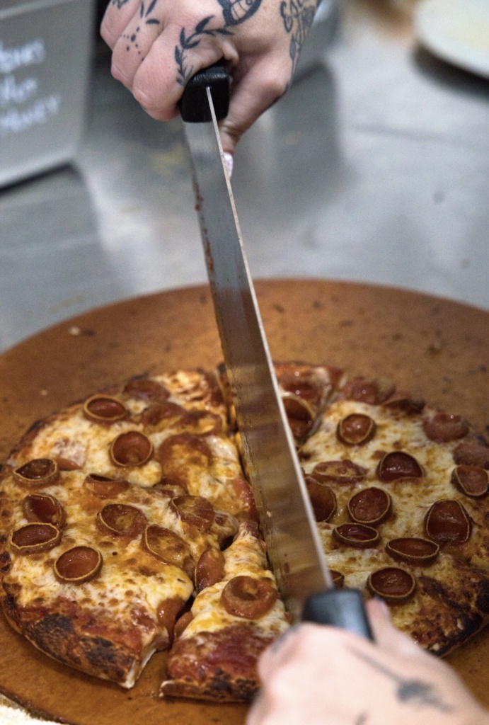 Pepperoni pizza being sliced at Mountain Mike’s Pizza in Keller