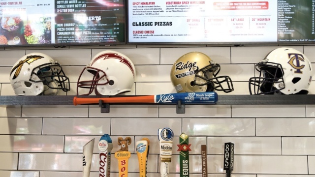 Local football helmets and beer taps beneath the menu at Mountain Mike’s Pizza in Keller